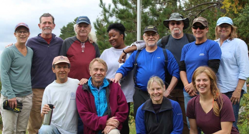 A group of people pose for a group photo during a service project with Outward Bound.